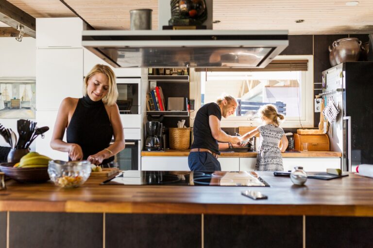 Parents preparing food with daughter (2-3) in kitchen